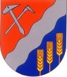Wappen durch silbernen schräglinken Wellenbalken geteilt, oben in Rot schräggekreuzt, silberner Dachdeckerhammer und Rodehacke, unten in Blau drei goldene Ähren aus dem Schildrand wachsend.