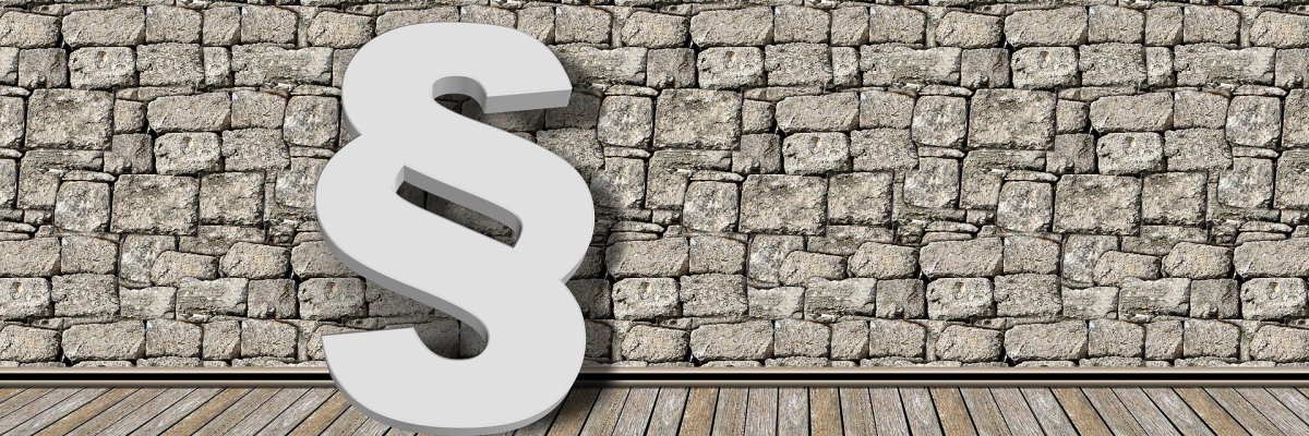 Ein Bild eines Paragraphenzeichens vor einer gemauerten Wand