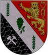 Schild durch silbernen Schrägbalken, belegt mit einem grünen Eichblatt und zwei grünen Ähren oben und unten, jeweils schräggeteilt; oben in Rot ein herschauender blaubewehrter und -gezungter goldener Löwe, unten auf schwarzem Schiefer schräggekreuzt silberner Hammer und Schlägel.