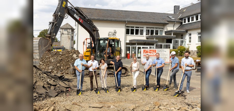 Im Bild von links nach rechts : Ortsbürgermeister Wilfried Oettgen, Erster Beigeordneter der Verbandsgemeinde Marco Dörner, Schulleiterin Alexandra Marx, Geschäftsführer Ansgar Ritz (Architekturbüro Ritz&Losacker), Katrin Lück vom Fachbereich Bauen und Regionalentwicklung der Verbandsgemeinde, Fachbereichsleiter der Verbandsgemeinde für den Bereich Schulen Michael Ebener, Fachbereichsleiter der Verbandsgemeinde für den Bereich Bauen und Regionalentwicklung Björn Oettgen, Bauleiter der bauausführenden Firma Dickopf-Bau GmbH Bernd Meier, Bauleiter des Architekturbüros Ritz & Losacker Rene Schermuly. 