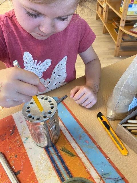 Ein Kind der Kindertagesstätte Dreilindenstein bei der Gestaltung eines „Insektenhotels.