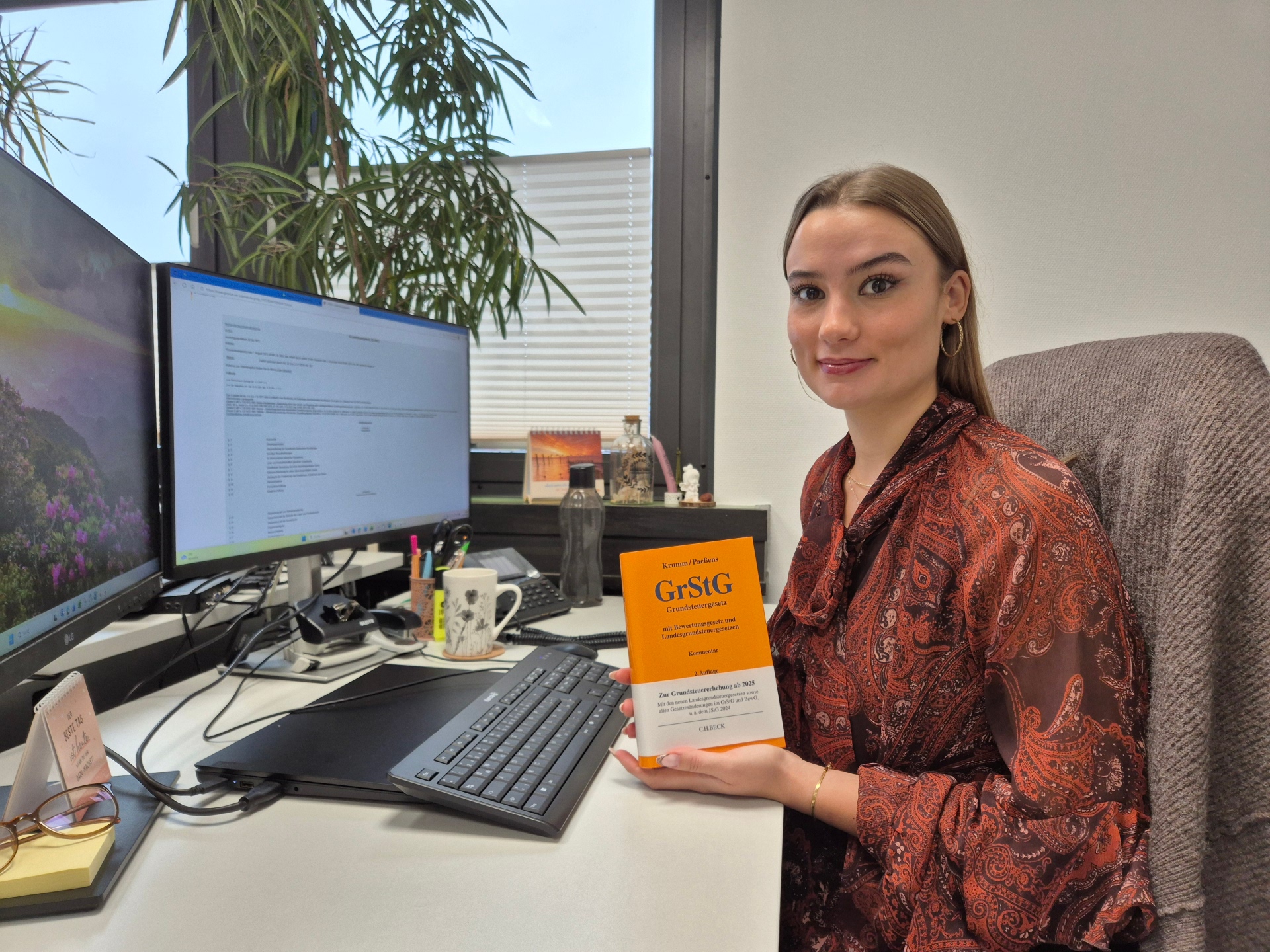 Eine Angestellte der Verbandsgemeinde Hachenburg mit dem Grundsteuergrundgesetz in der Hand
