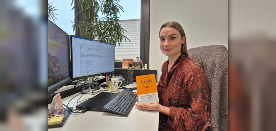 Eine Angestellte der Verbandsgemeinde Hachenburg mit dem Grundsteuergrundgesetz in der Hand