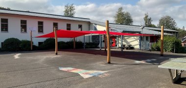 Das Sonnensegel an der Grundschule Atzelgift-Streithausen wurde mittels Pfosten aus Robinienholz auf dem Pausenhof errichtet und weist hierdurch eine natürliche Optik auf. 