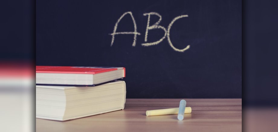 Zwei Bücher die vor einer Schultafel liegen