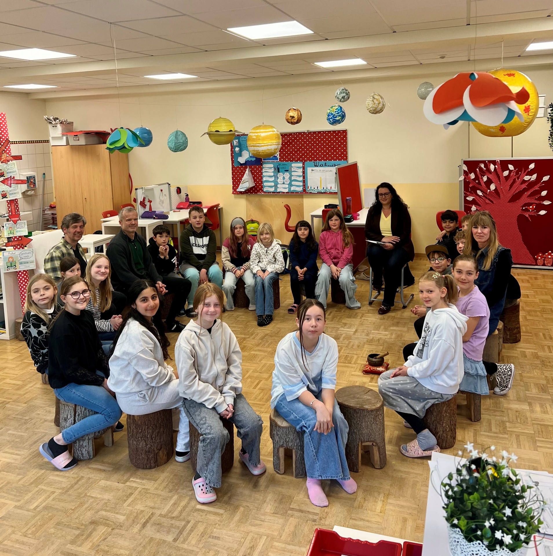 Kinder sitzen in einem Stuhlkreis