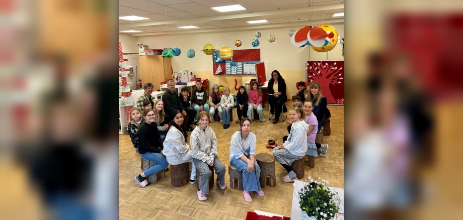 Kinder sitzen in einem Stuhlkreis