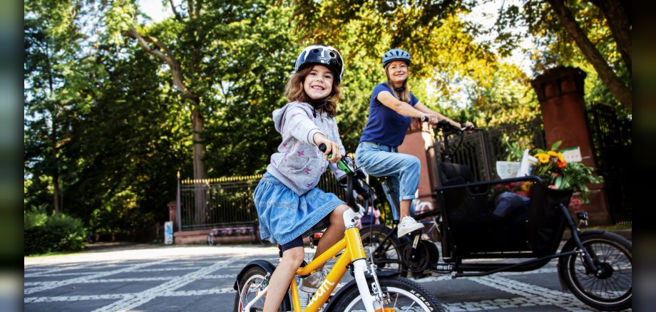 Frau und Mädchen, jeweils auf einem Fahrrad