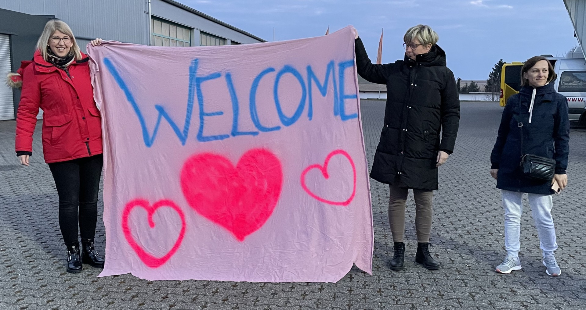 Menschen mit einem Welcome Plakat in der Hand