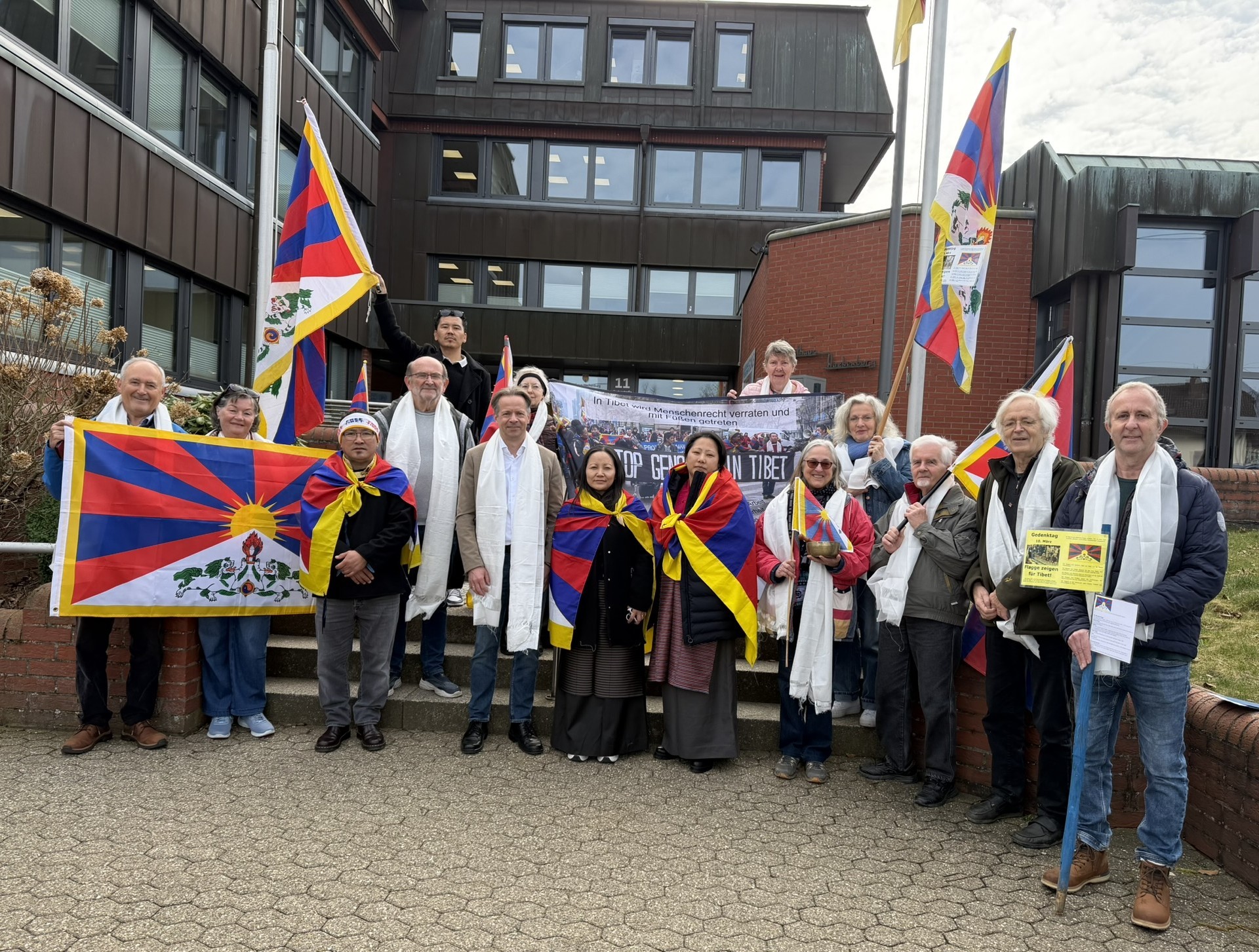 Gäste aus Tibet sowie Vertreterinnen und Vertretern der Tibet-Freunde Westerwald und der Erste Beigeordnete Marco Dörner vor dem Gebäude der Verbandsgemeindeverwaltung Hachenburg