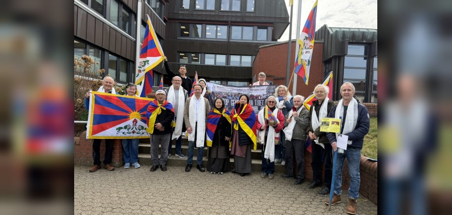 Gäste aus Tibet sowie Vertreterinnen und Vertretern der Tibet-Freunde Westerwald und der Erste Beigeordnete Marco Dörner vor dem Gebäude der Verbandsgemeindeverwaltung Hachenburg