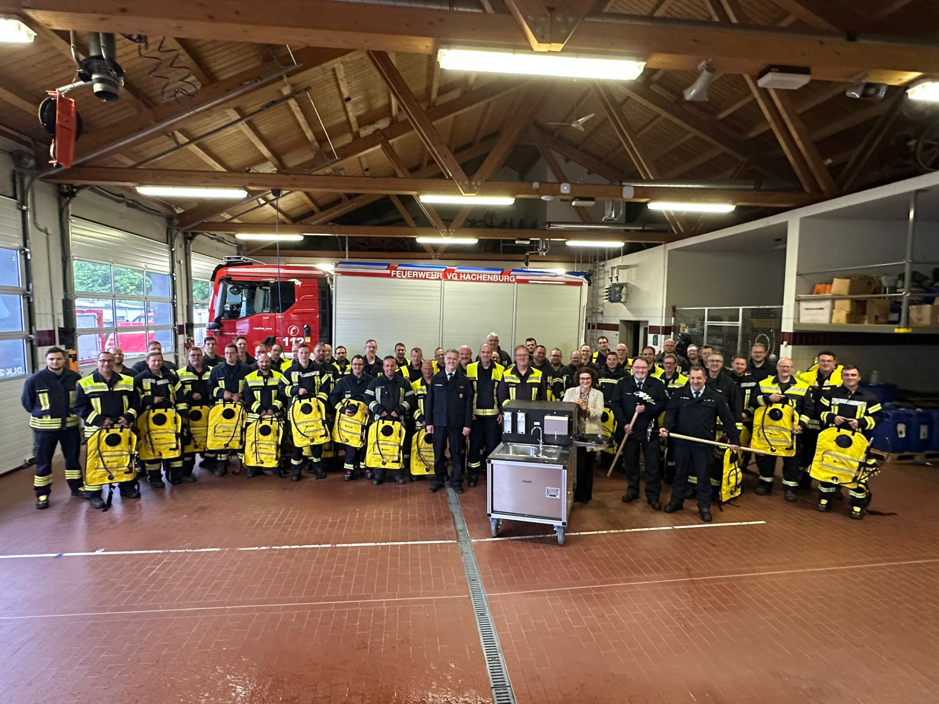 Feuerwehrkameraden vor einem Feuerwehrfahrzeug