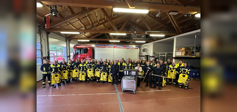 Feuerwehrkameraden vor einem Feuerwehrfahrzeug