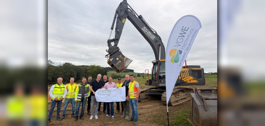 Erster Beigeordneter Marco Dörner, stellvertretender technischer Werkleiter Torsten Löhr, Bauingenieur Ronny Strunk und Ortsbürgermeister Peter Enders zusammen mit Vertretern des Bauunternehmens Robert Schmidt sowie dem Planungsbüro Gewatec beim zukünftigen Neubaugebiet in Hattert